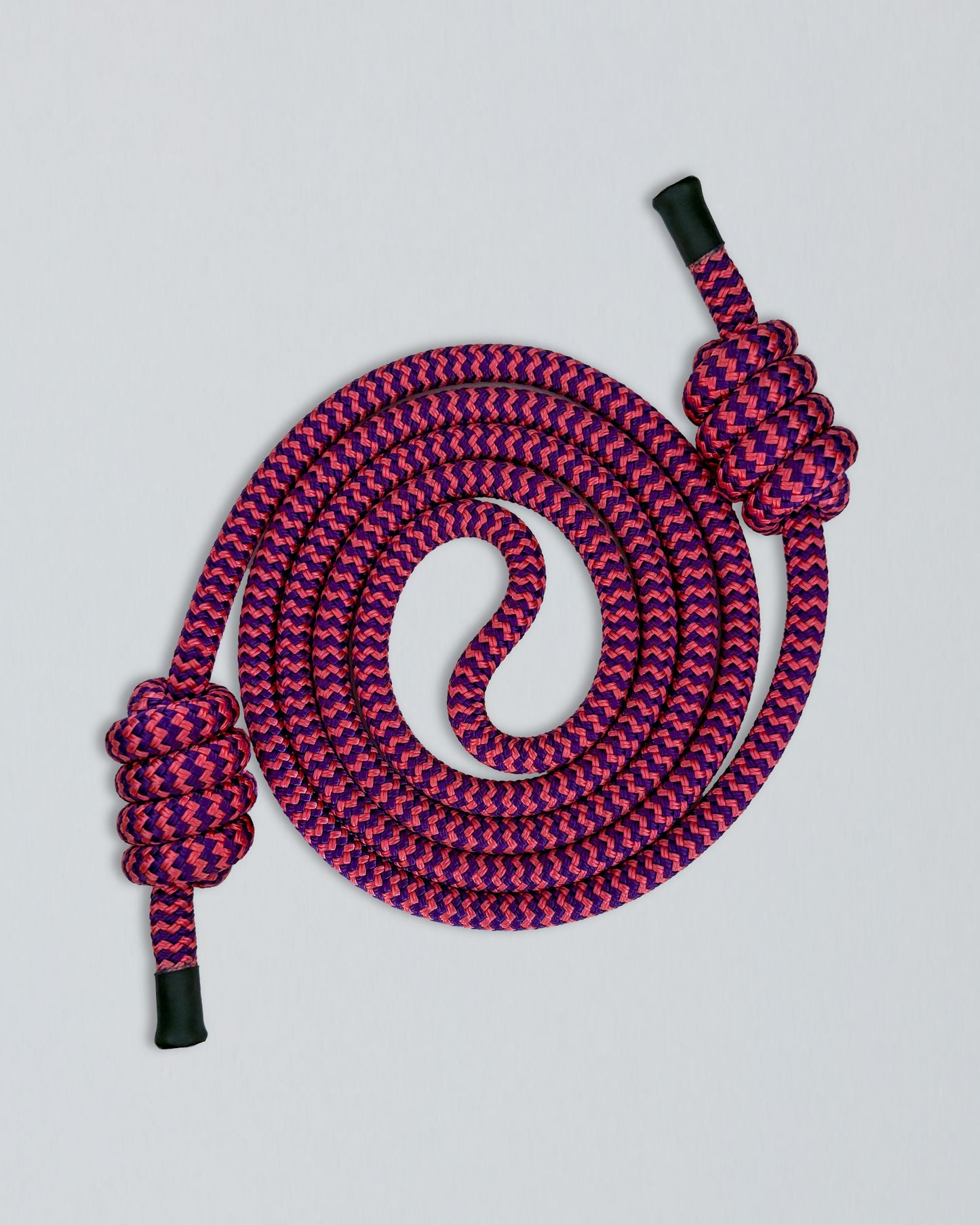Pink and purple braided rope with a knot and black end caps on a light gray background